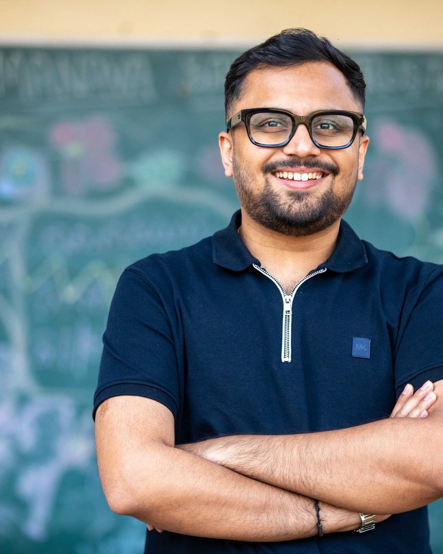 Portrait of a smiling man in glasses in front of a chalkboard